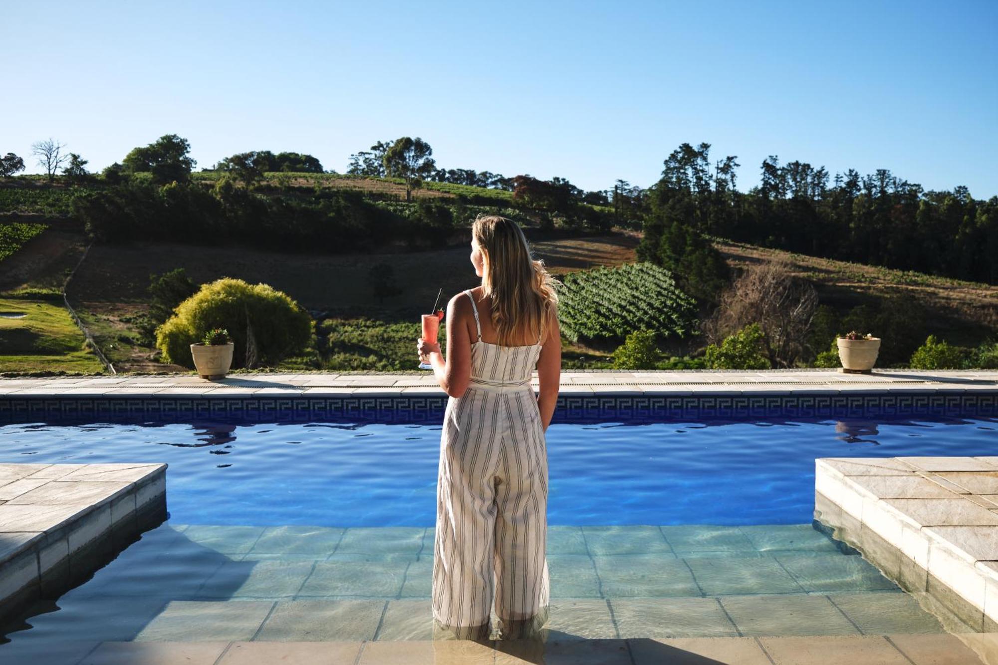 Alluvia Boutique Winery & Luxury Accommodation 斯泰伦博斯 客房 照片 A woman standing by a pool