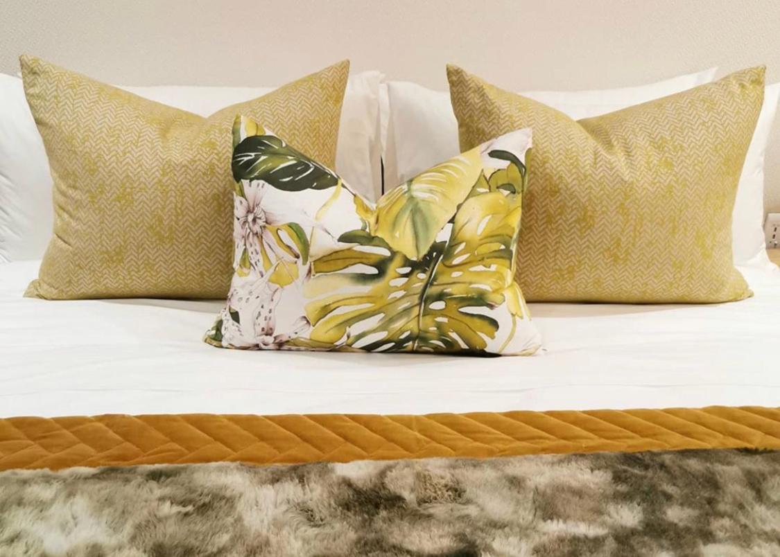 Alluvia Boutique Winery & Luxury Accommodation 斯泰伦博斯 客房 照片 A bed with decorative pillows
